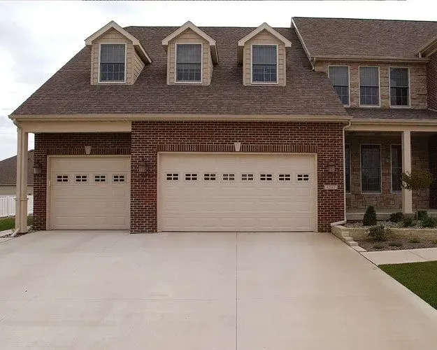 A large brick house with two white garage doors