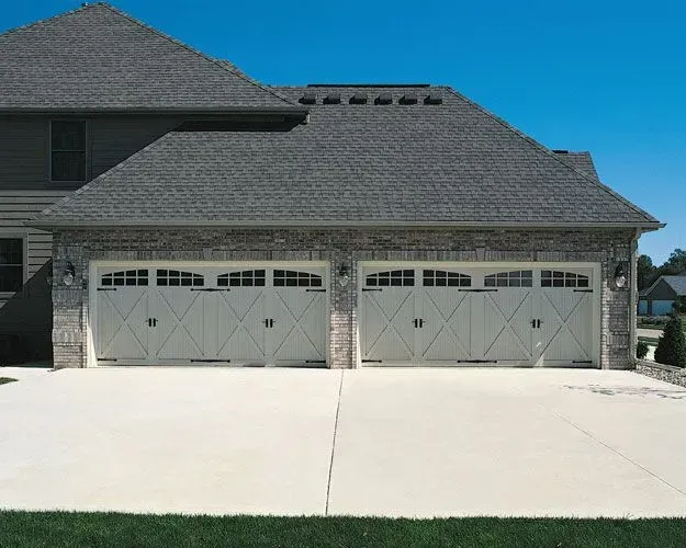 A large house with two garage doors and a concrete driveway