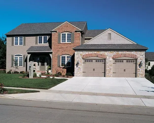 A large house with two garage doors and a driveway