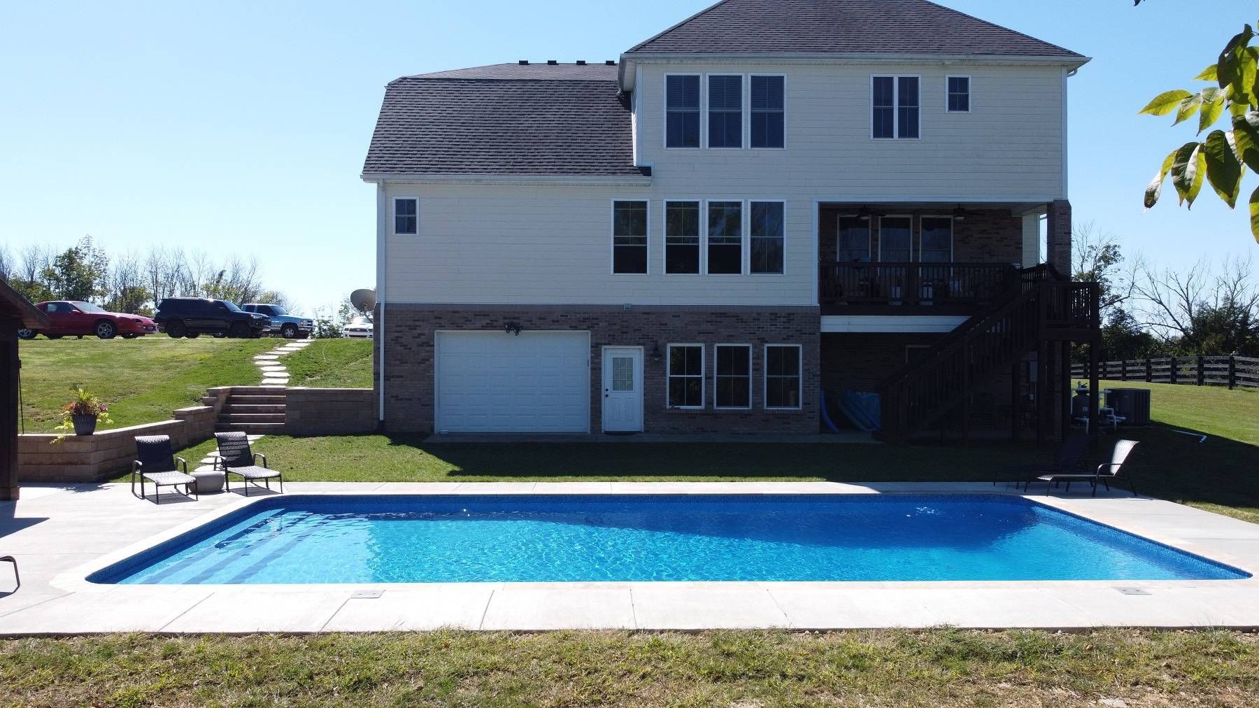 A large house with a large swimming pool in front of it