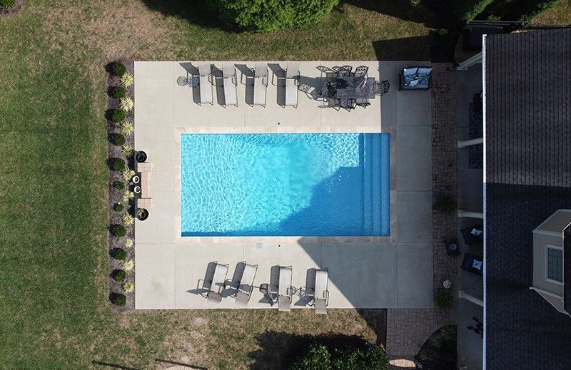 An aerial view of a large swimming pool surrounded by lawn chairs.