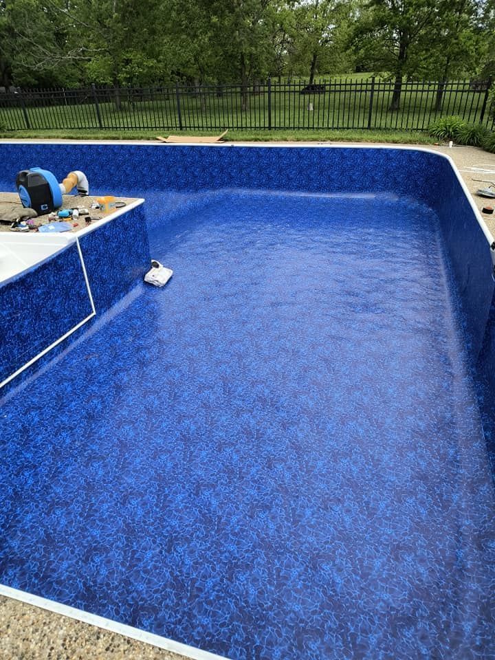 A large blue swimming pool is being built in a backyard.
