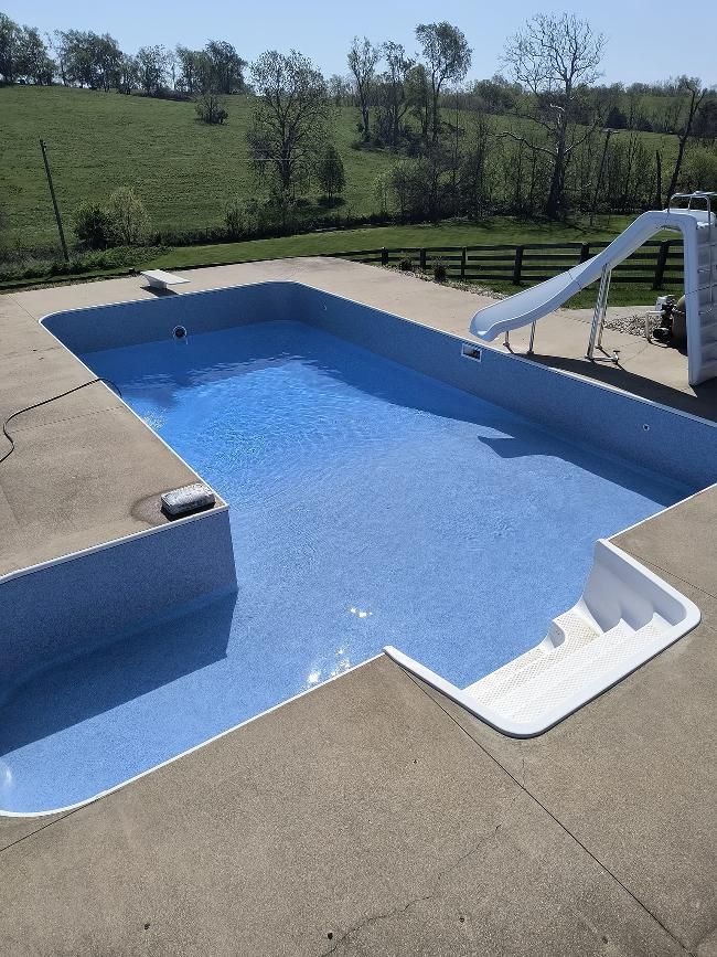 A large swimming pool with a slide attached to it
