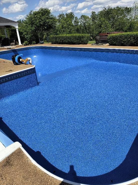 A large blue swimming pool is being built in a backyard.