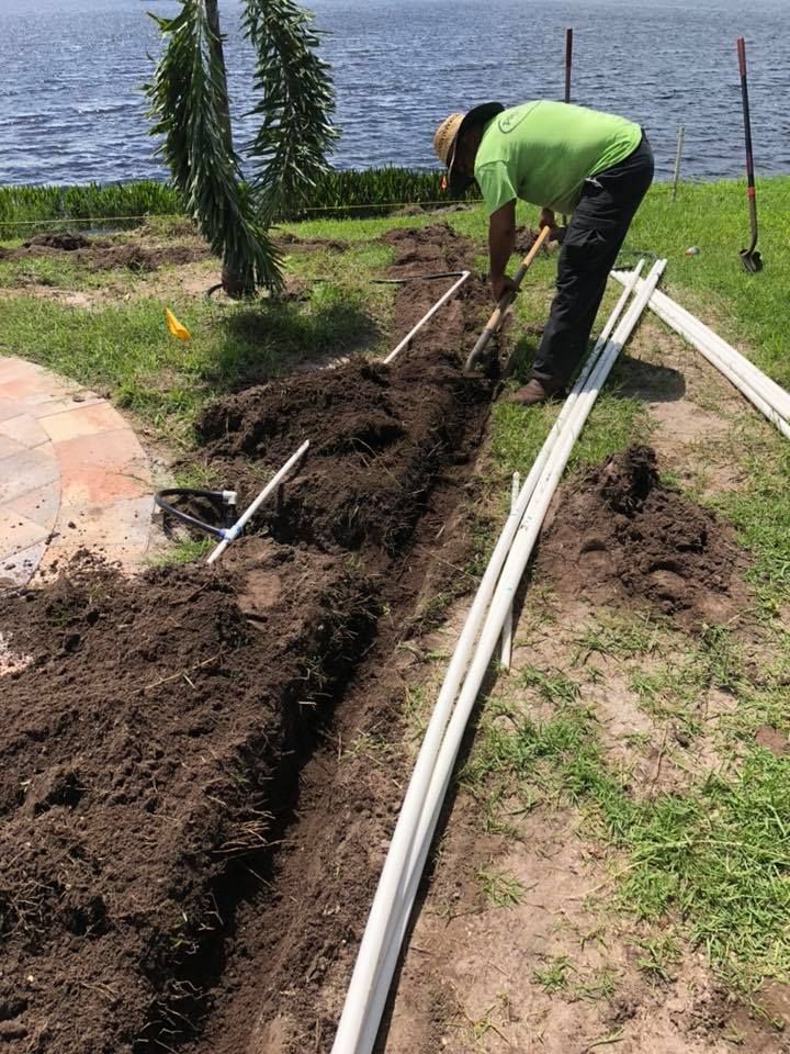 A man is digging a hole in the ground with a shovel.