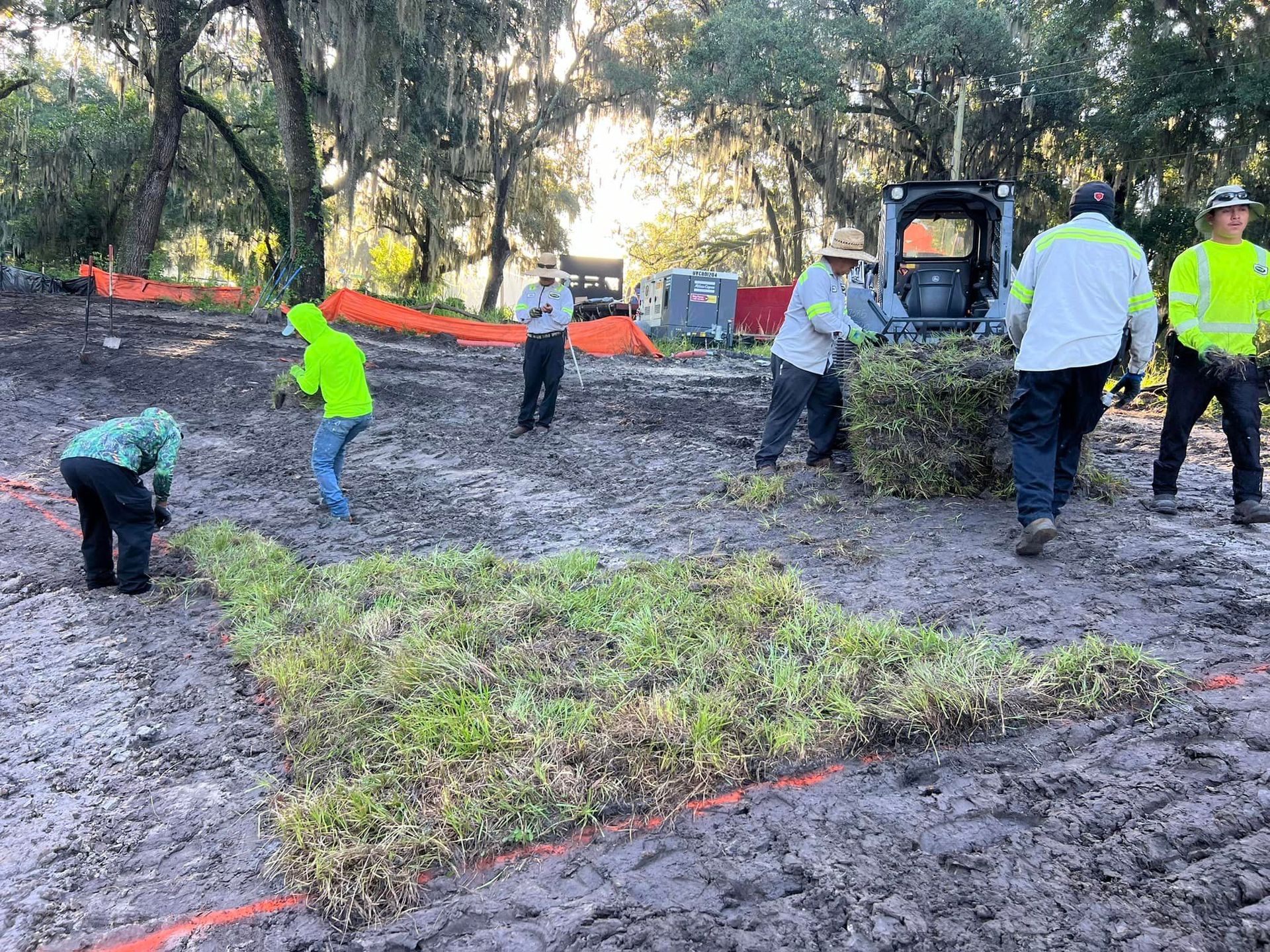A group of people are working in a muddy field.