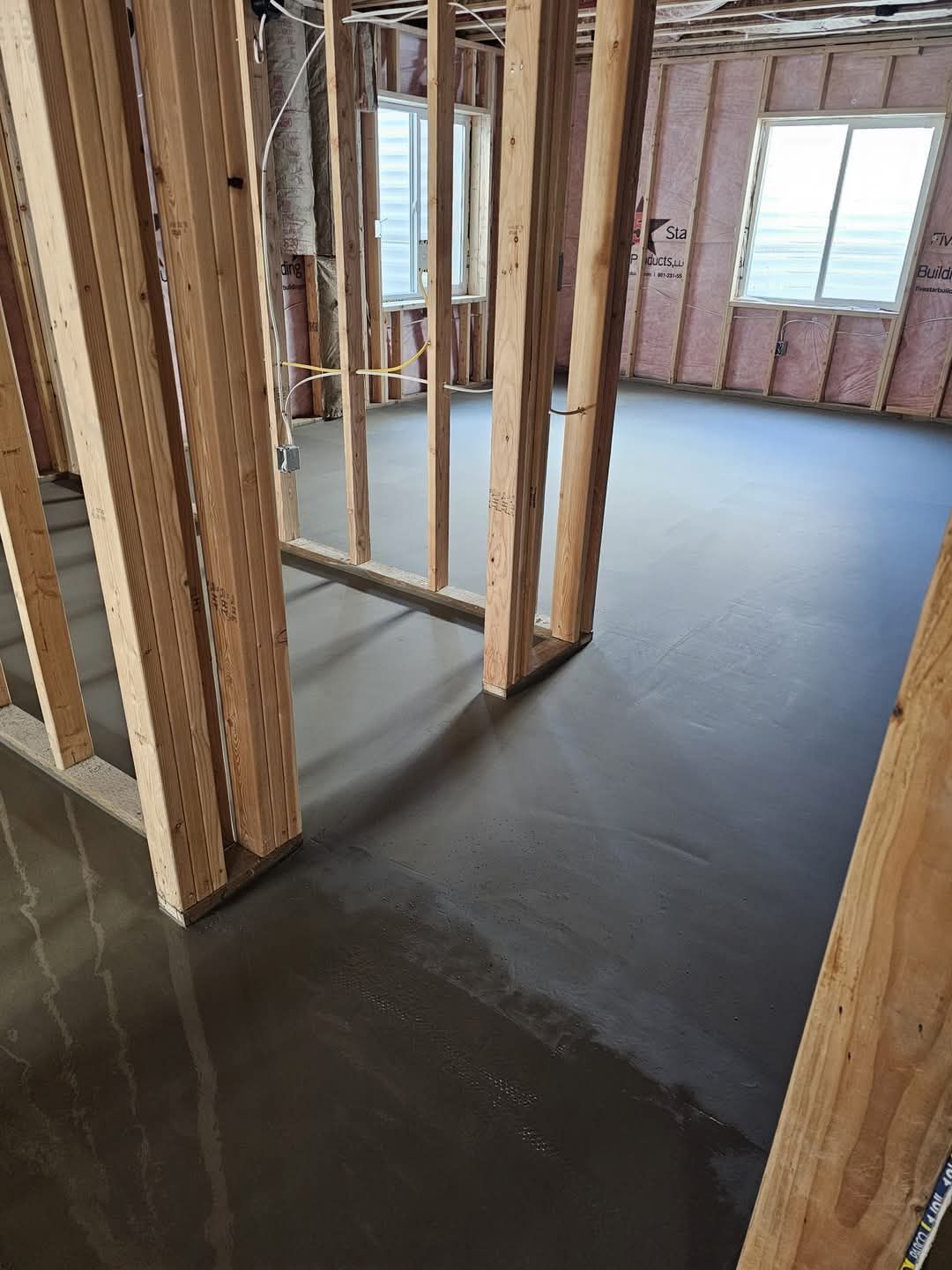 A room in a house under construction with a concrete floor.
