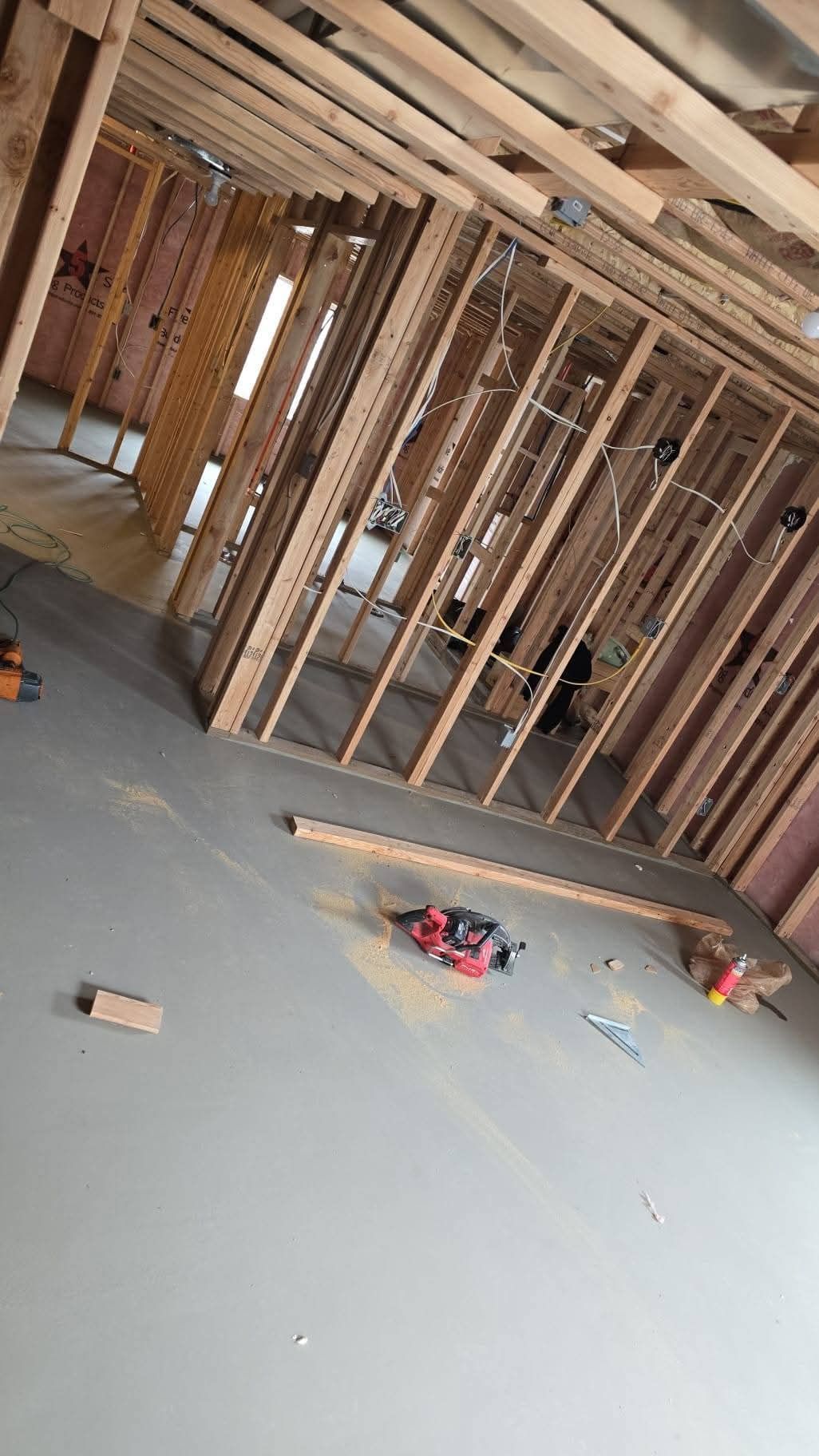 A room under construction with wooden beams and a concrete floor.