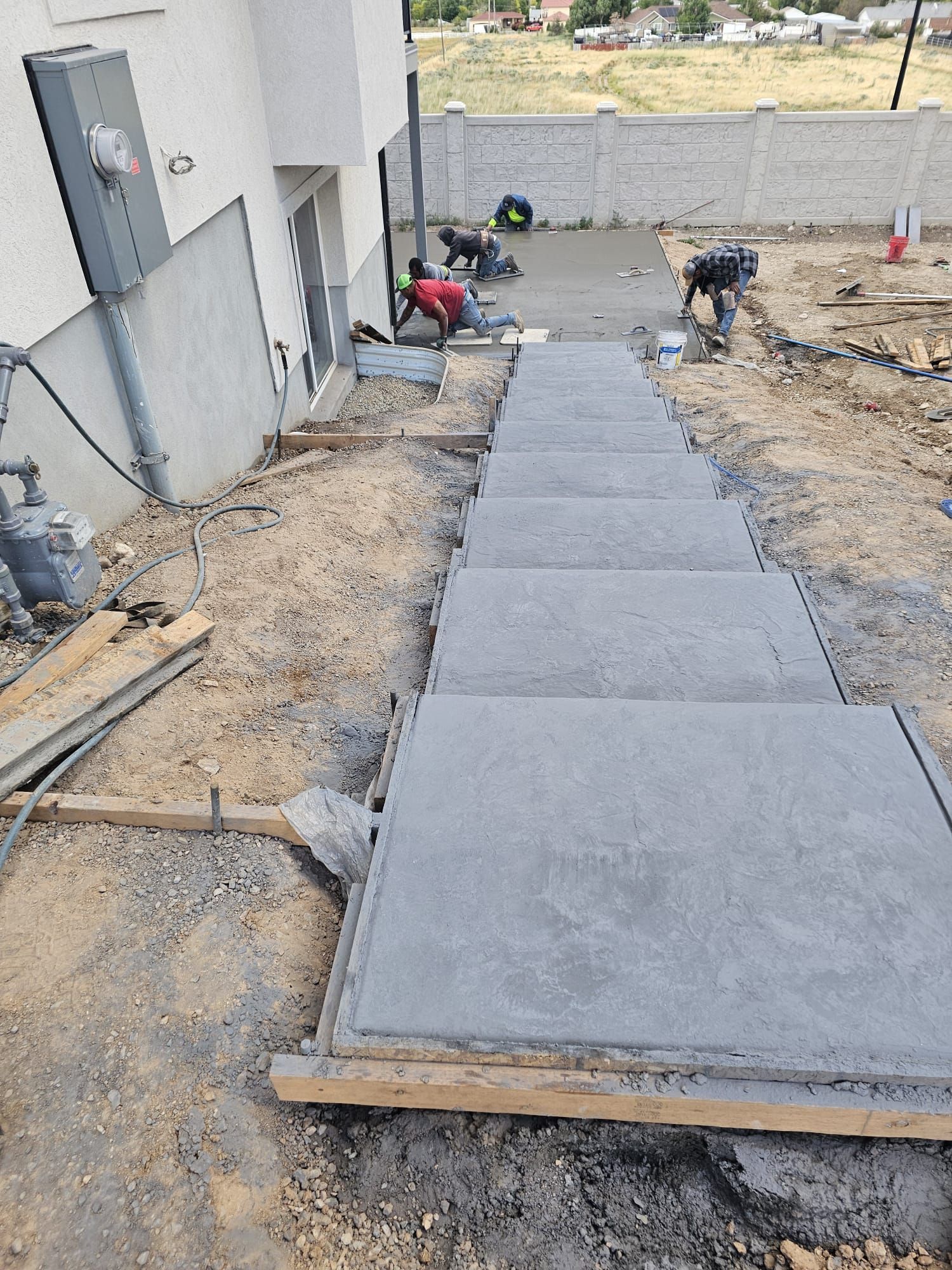 A concrete walkway is being built in front of a house.