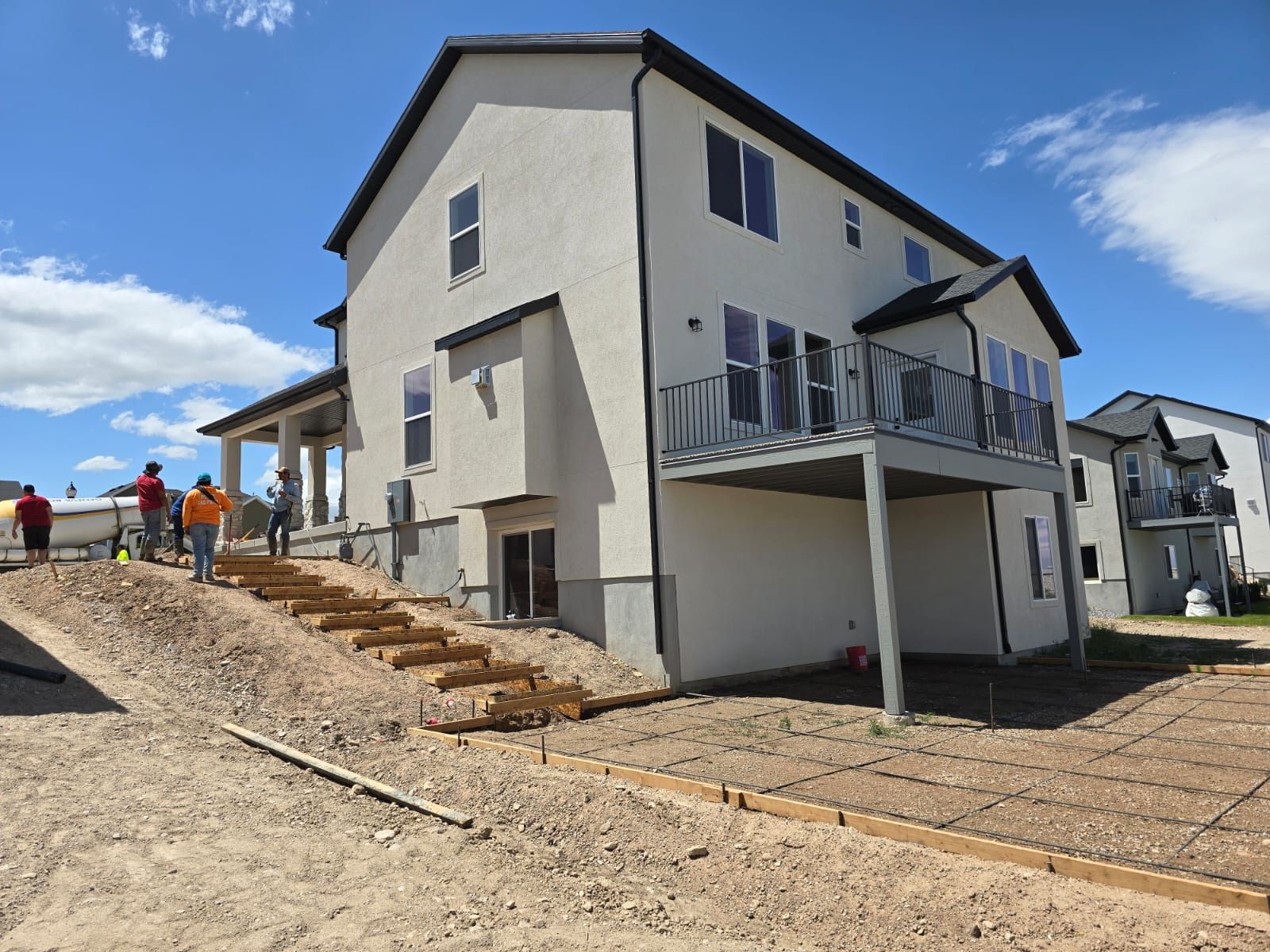A group of people are standing in front of a house that is being built.