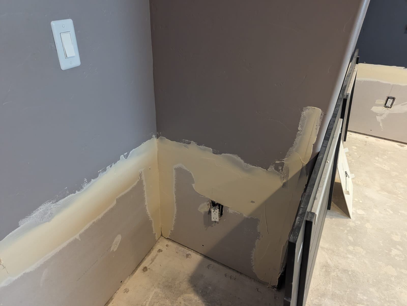 A corner of a room that is being painted.