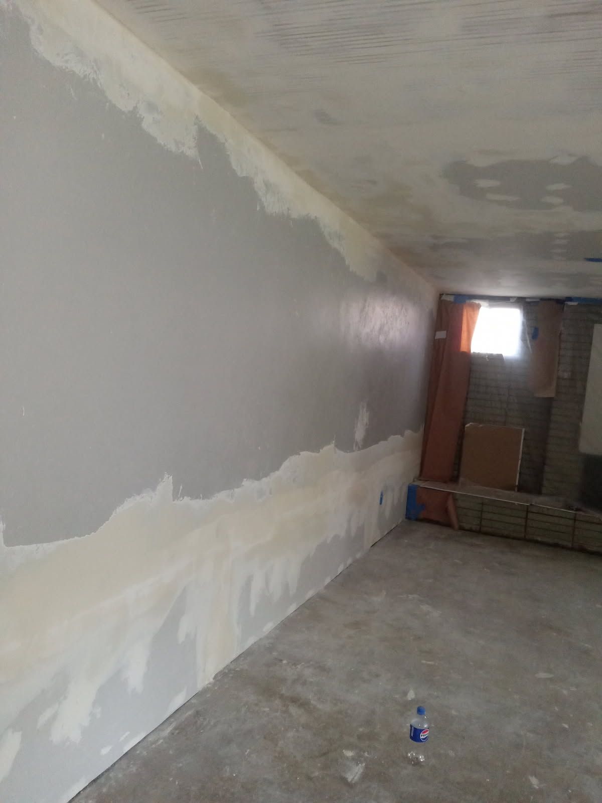 There is a bottle of water on the floor in the middle of the room.