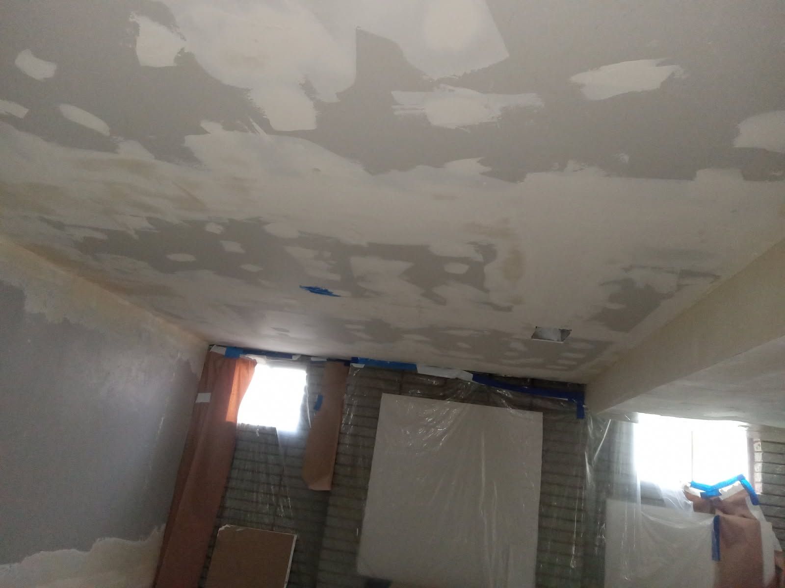 A person is spraying a ceiling with a spray bottle.