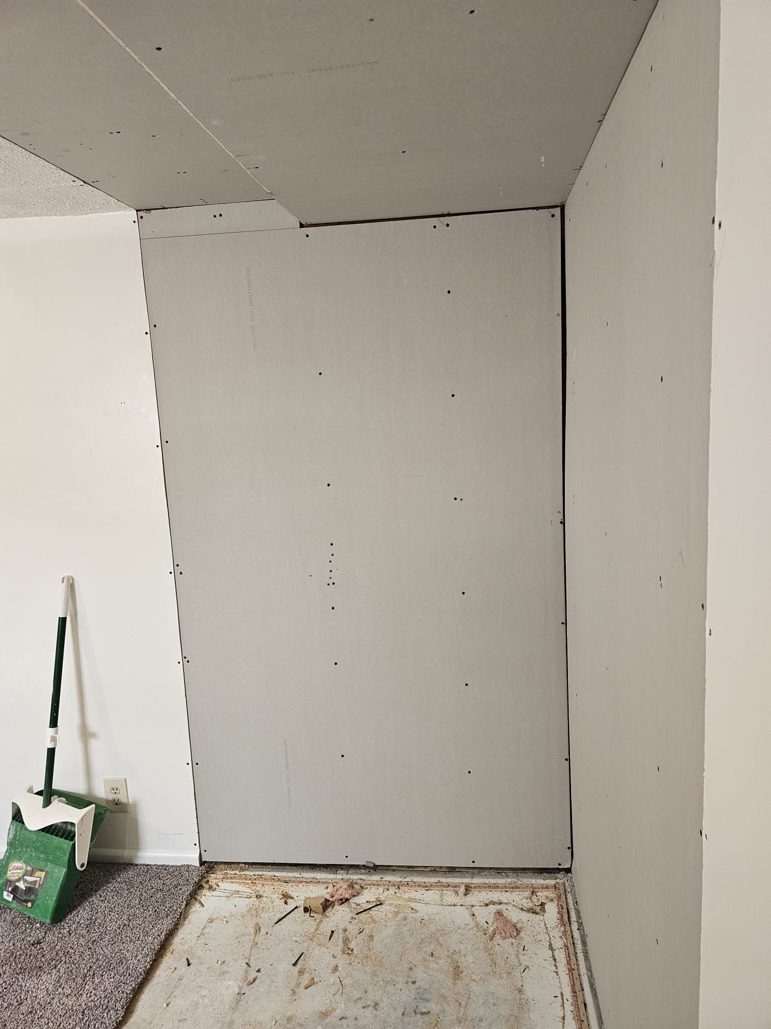 A room with a door and a broom in it.