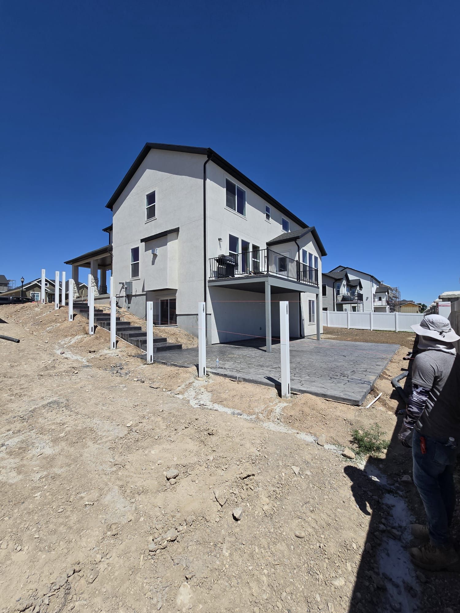 A large white house is sitting on top of a dirt hill.