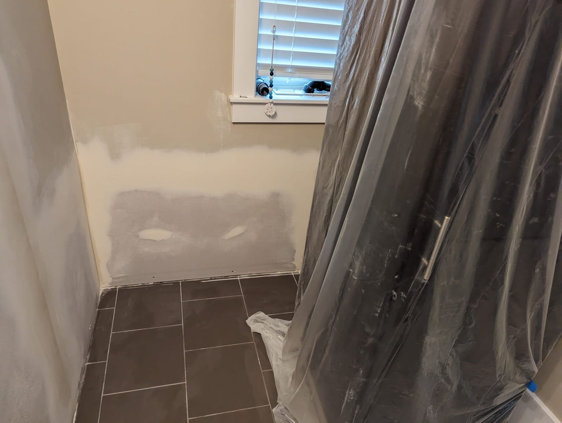 A bathroom with a shower curtain and a window.