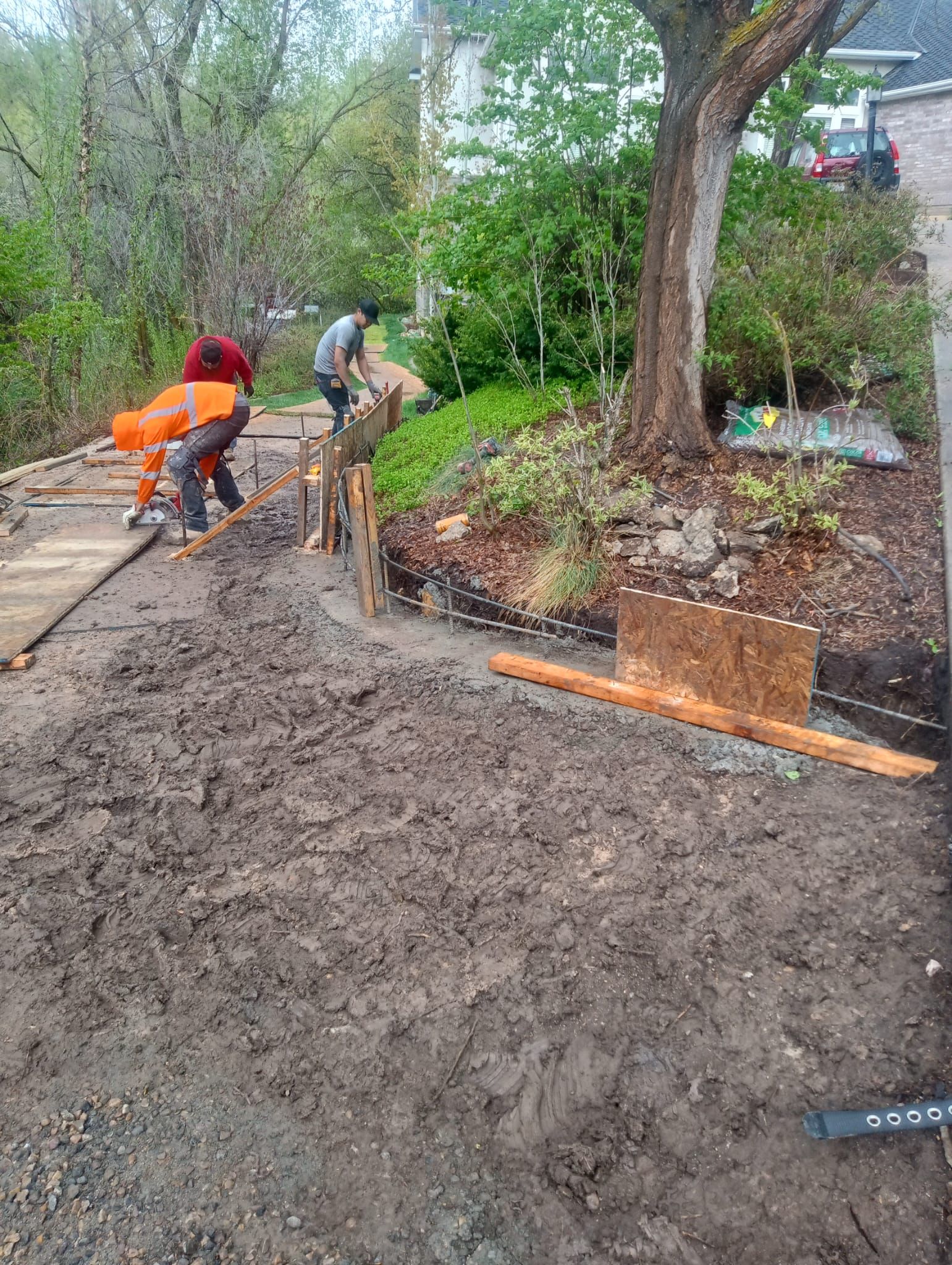 A group of people are working on a concrete walkway.