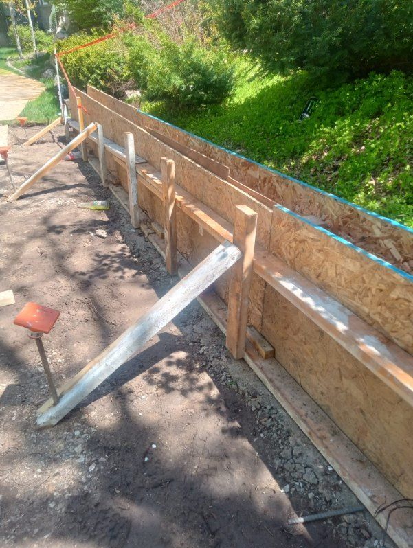 A wooden fence is being built on a dirt road.
