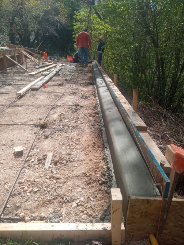 A group of men are working on a concrete foundation.