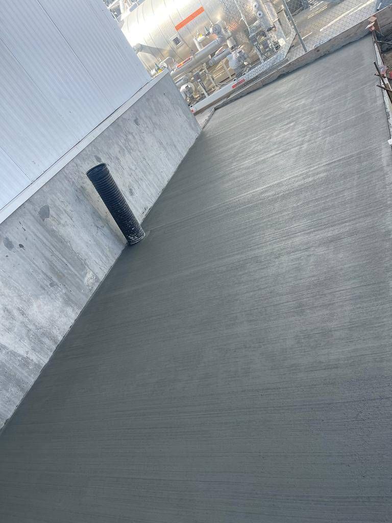 A concrete walkway is being built next to a building.