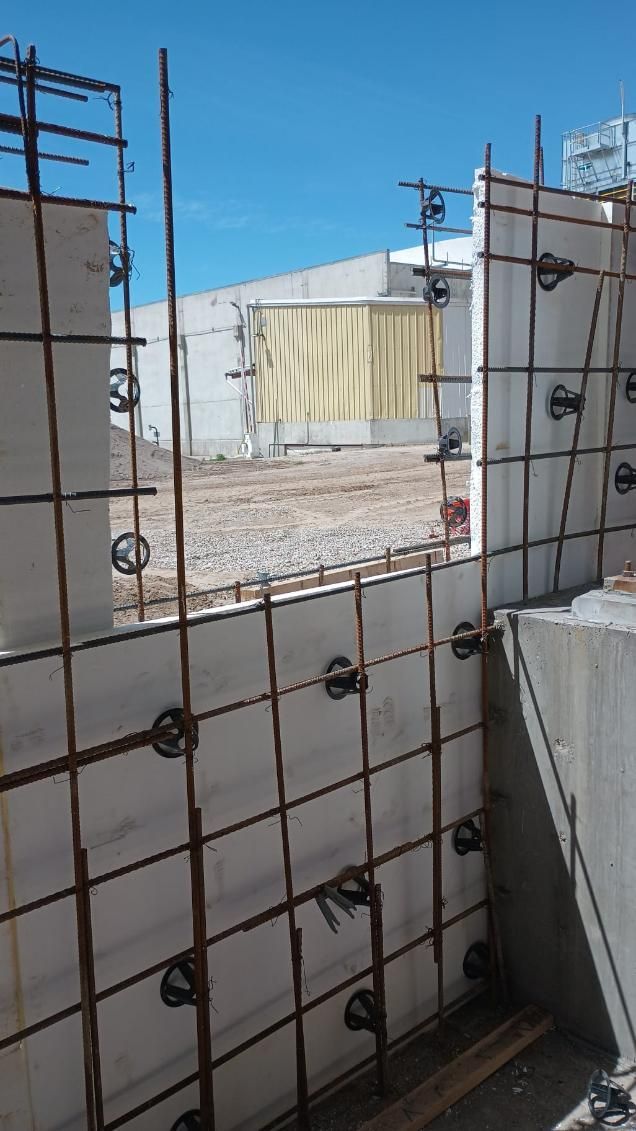 A concrete wall with a window in it is being built.