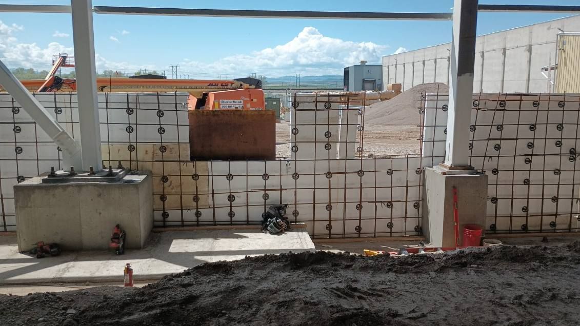 A concrete wall is being built on a construction site.