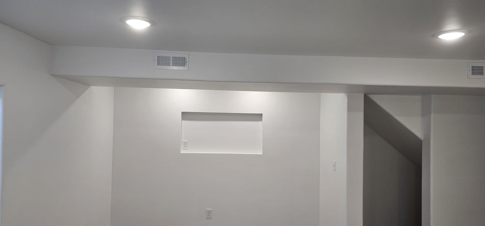An empty room with white walls and a white ceiling.
