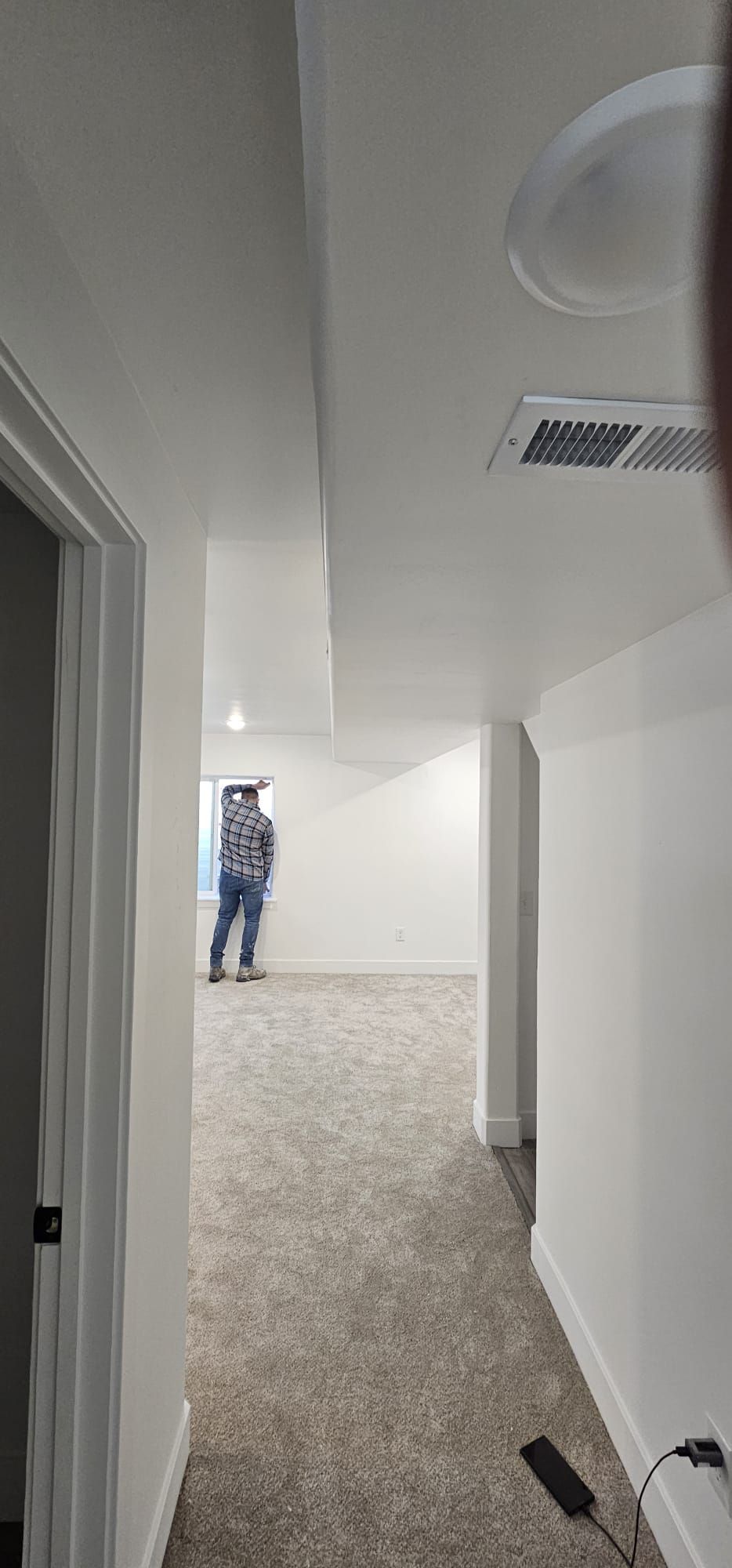 A man is standing in the middle of a hallway in a house.
