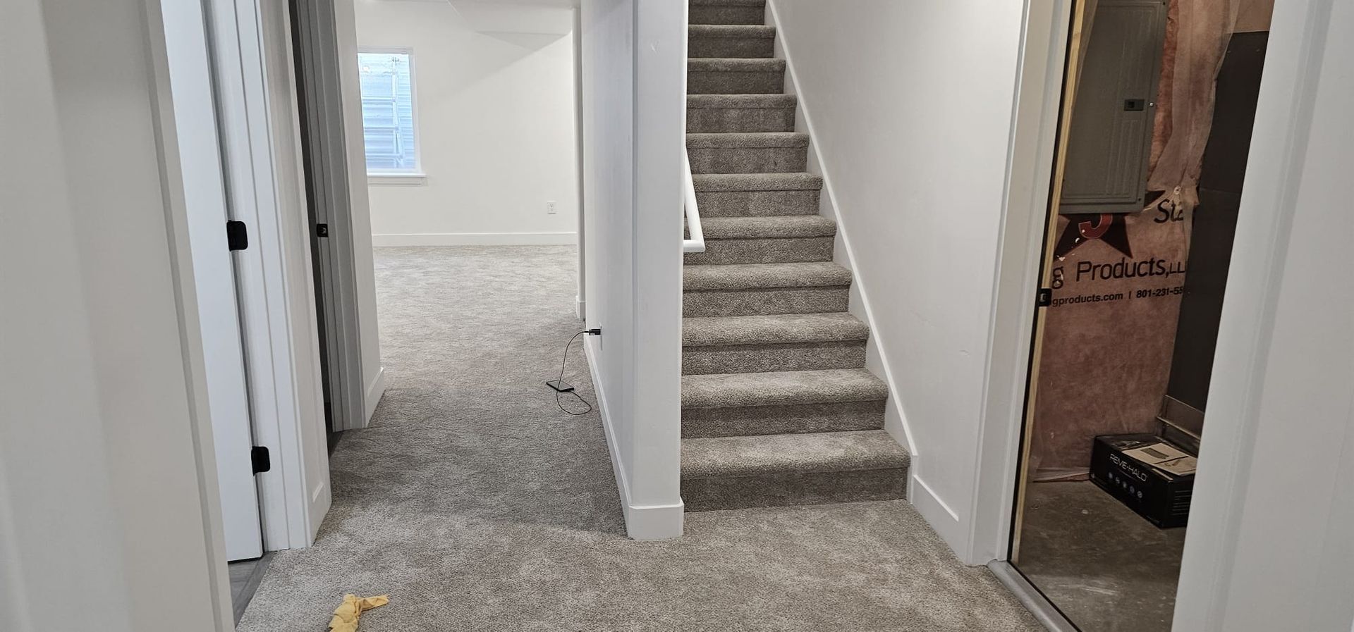 A hallway with stairs leading up to the second floor of a house.