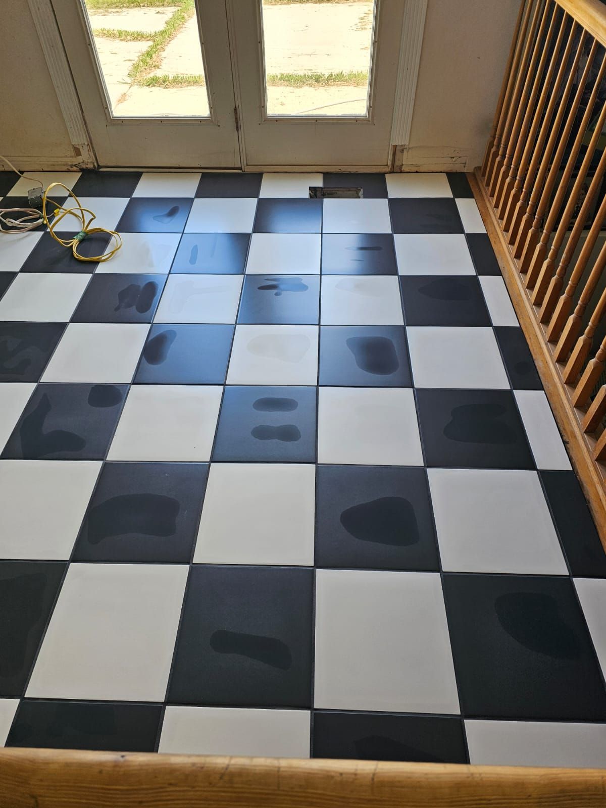 A black and white checkered floor with a wooden railing.