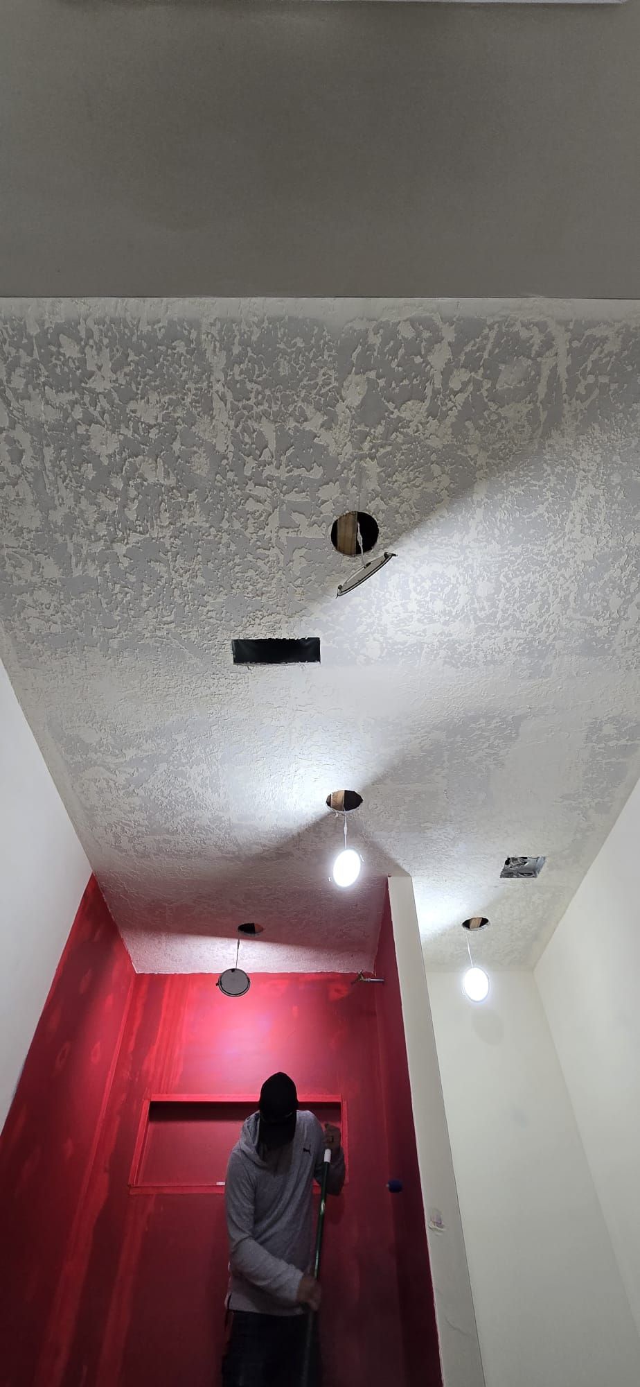 A man is standing in a hallway looking up at the ceiling.