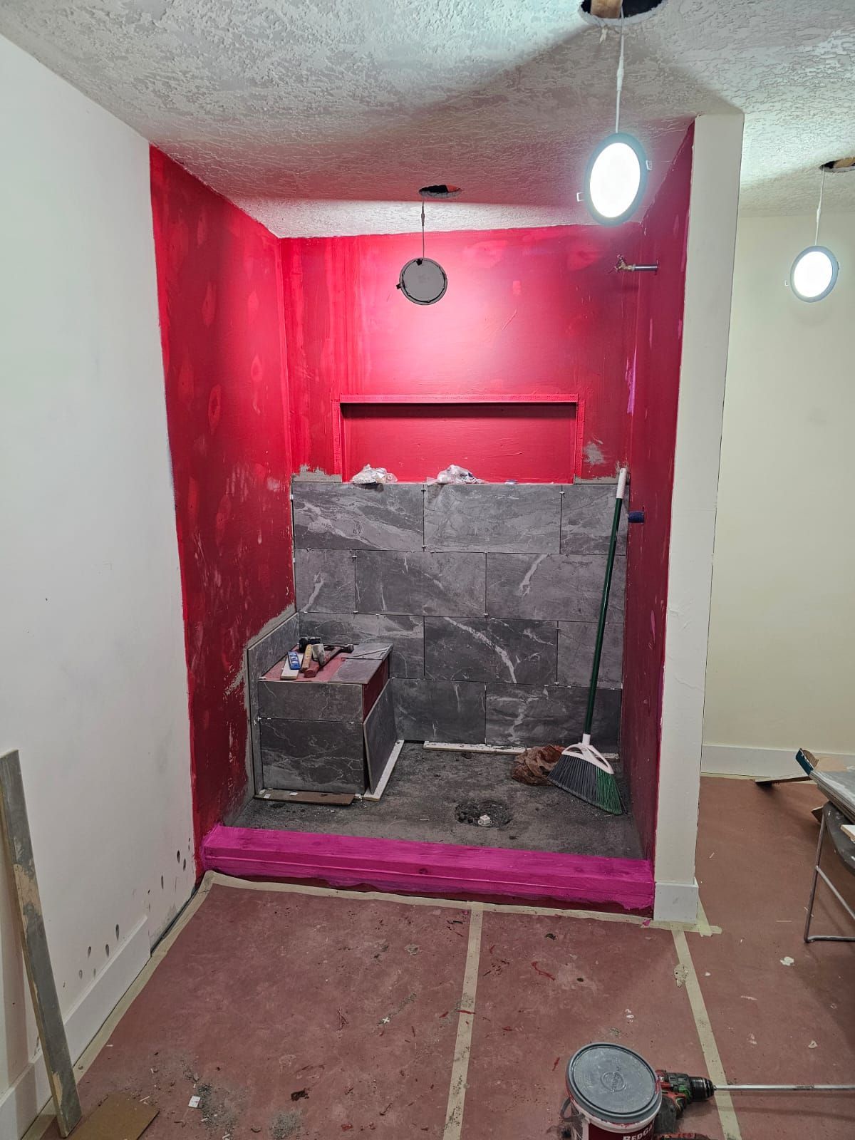 A room with red walls and a broom in it.