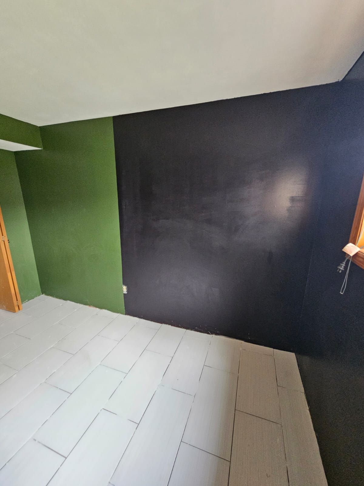 A room with green walls and a black wall.