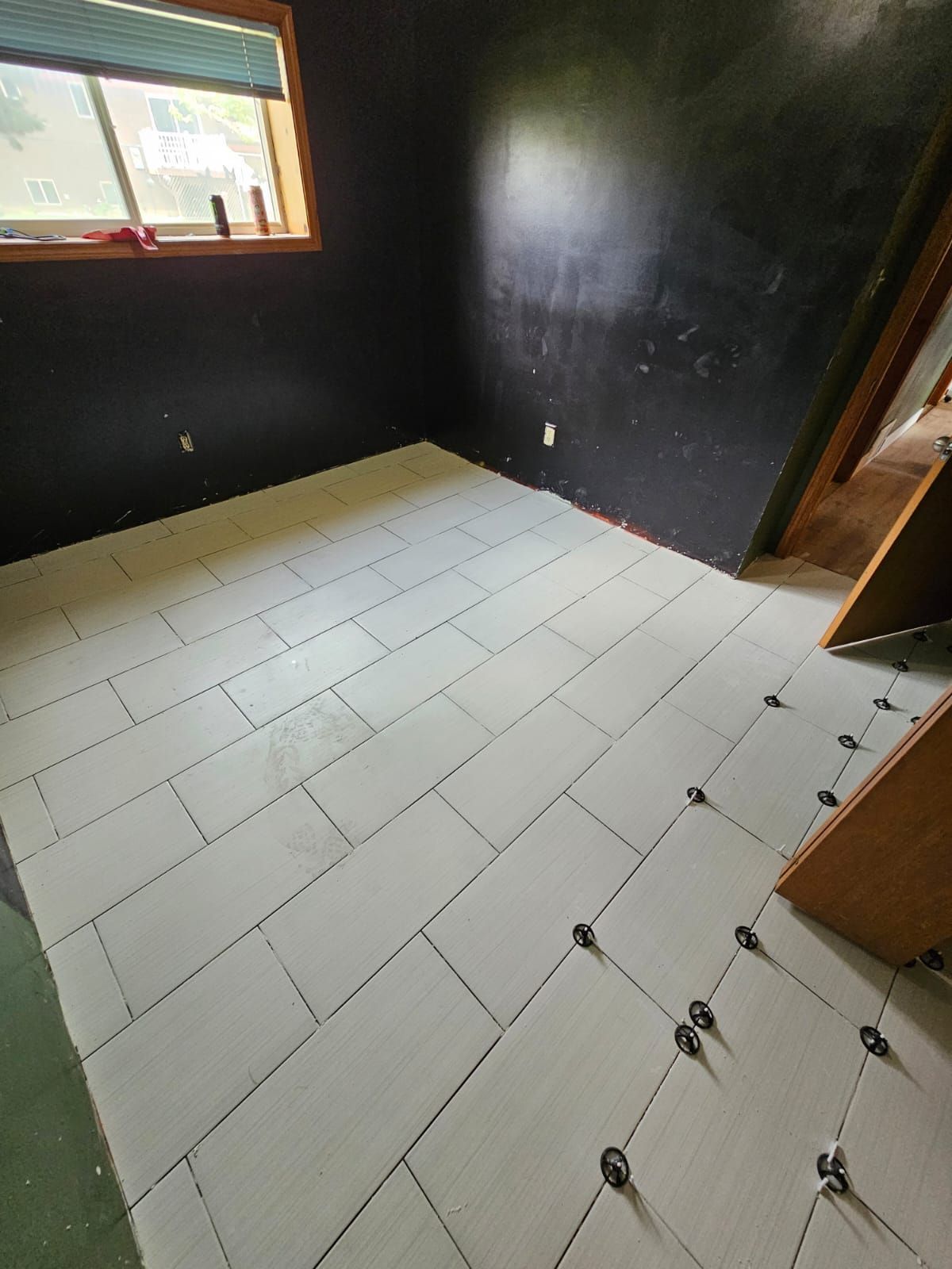 A room with a tiled floor and a window.