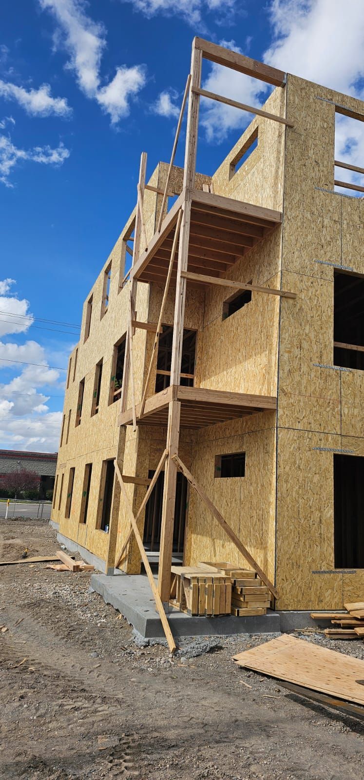 A large wooden building under construction with a ladder on the side of it.