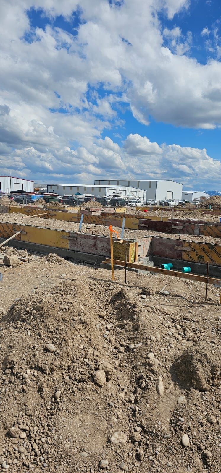 A construction site with a large building in the background.