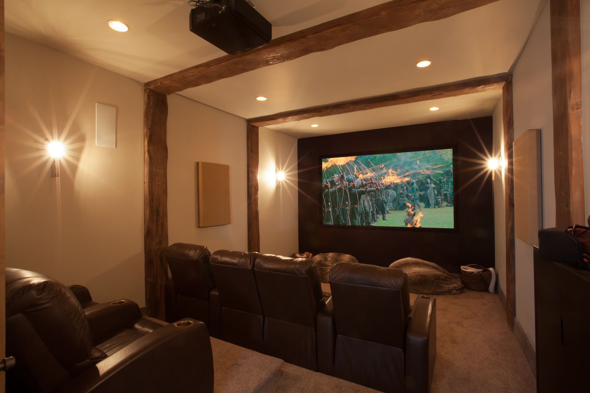 Home theater room with leather recliners facing a large screen showing a forest scene