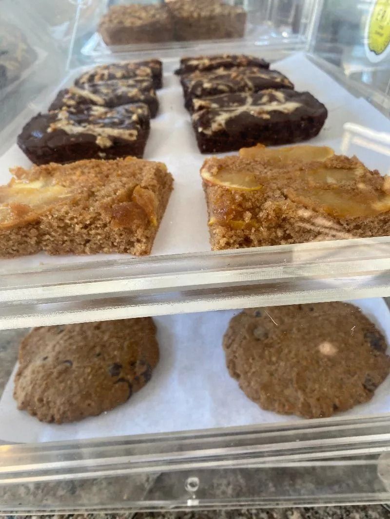 Baked goods in a display case: brownies, cookies, and bars.