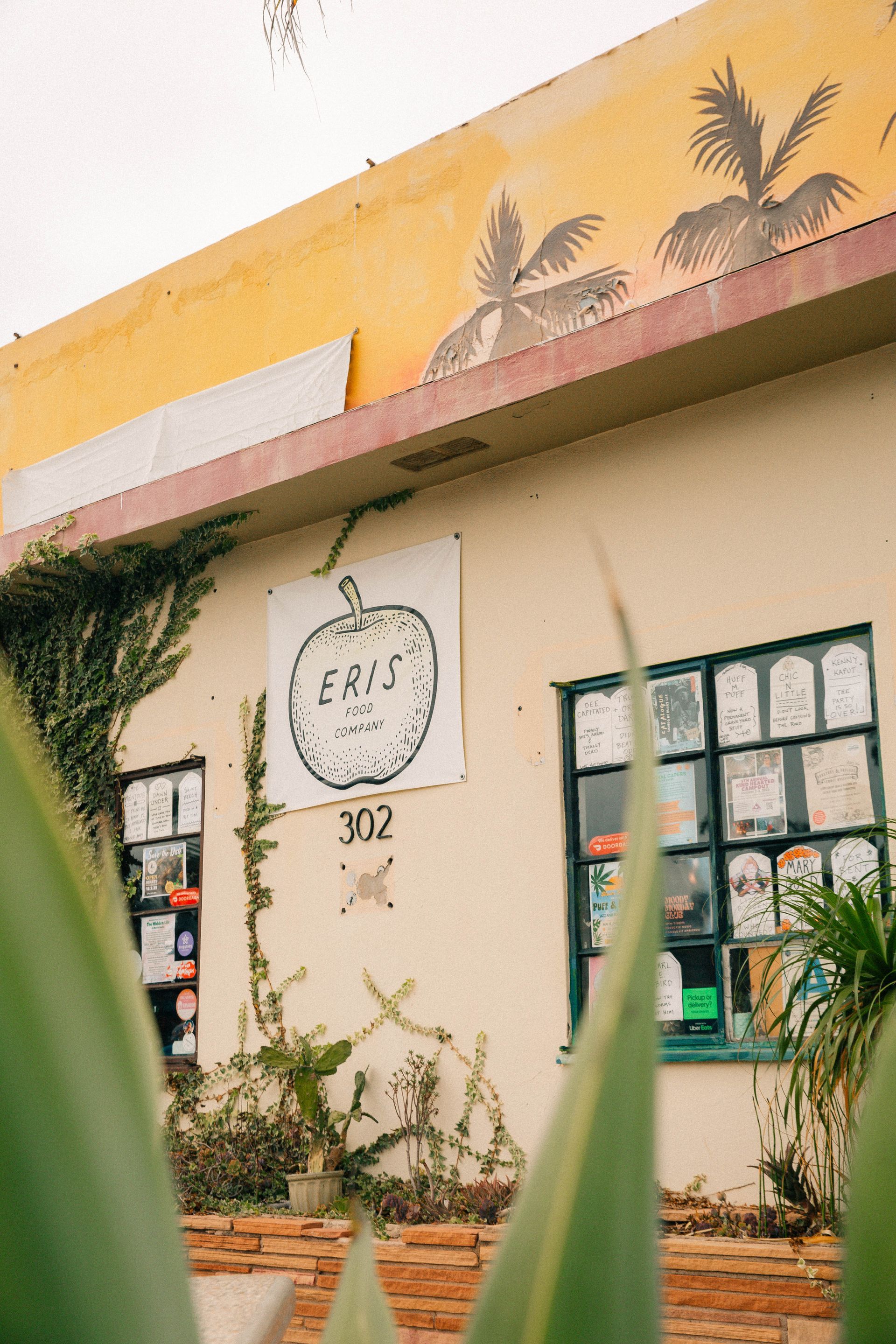 Exterior of a cream-colored building with an apple-shaped sign that reads 