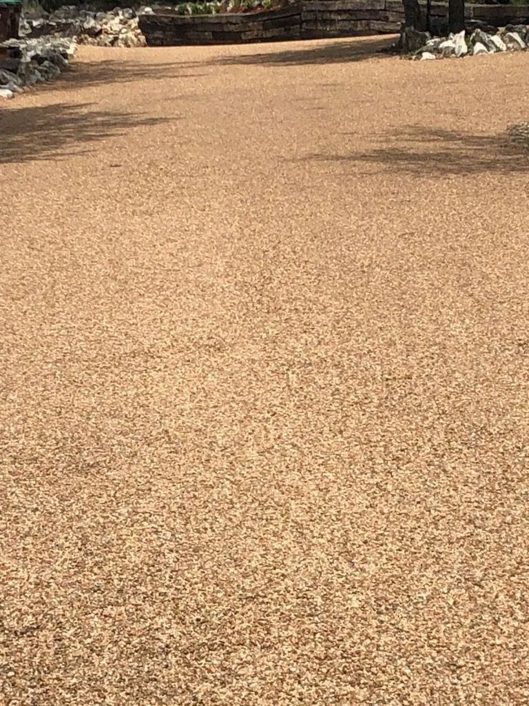 Gravel pathway in outdoor setting; light brown and tan pebbles.