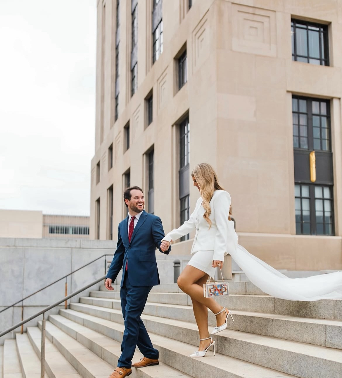 Couple holding hands, descending outdoor stairs of a building