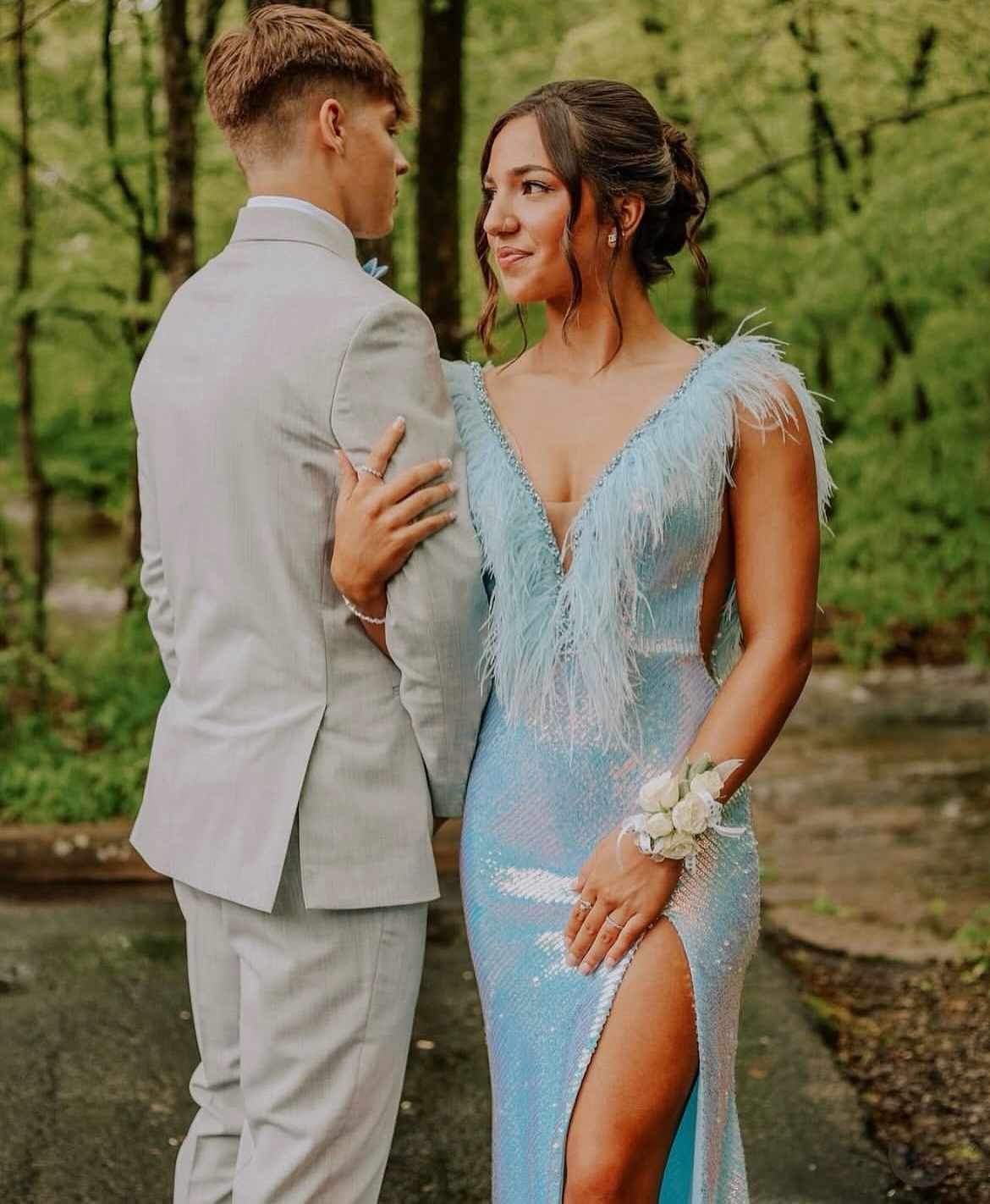 Couple at prom: the woman in a blue sequined dress with feathers