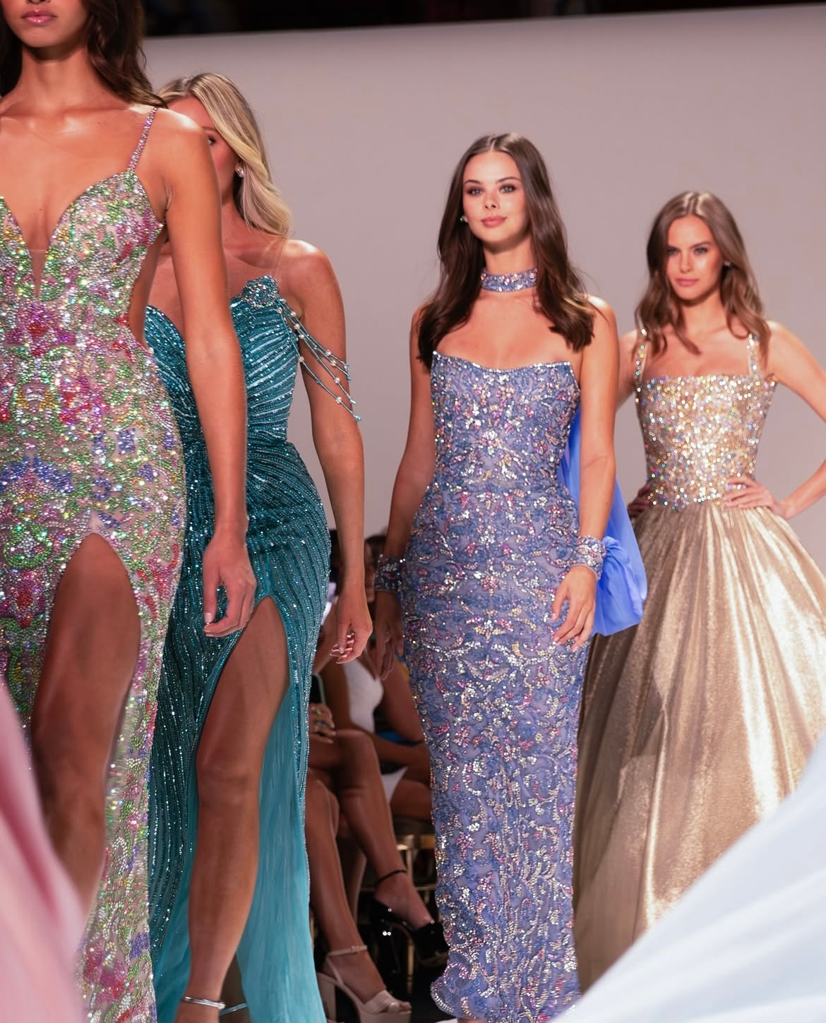 Models in sparkly gowns walking a runway