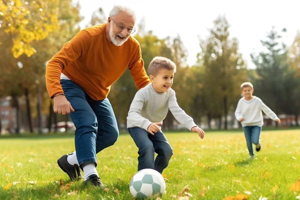 Adult and child playing soccer in a sunny park, with another child in the background