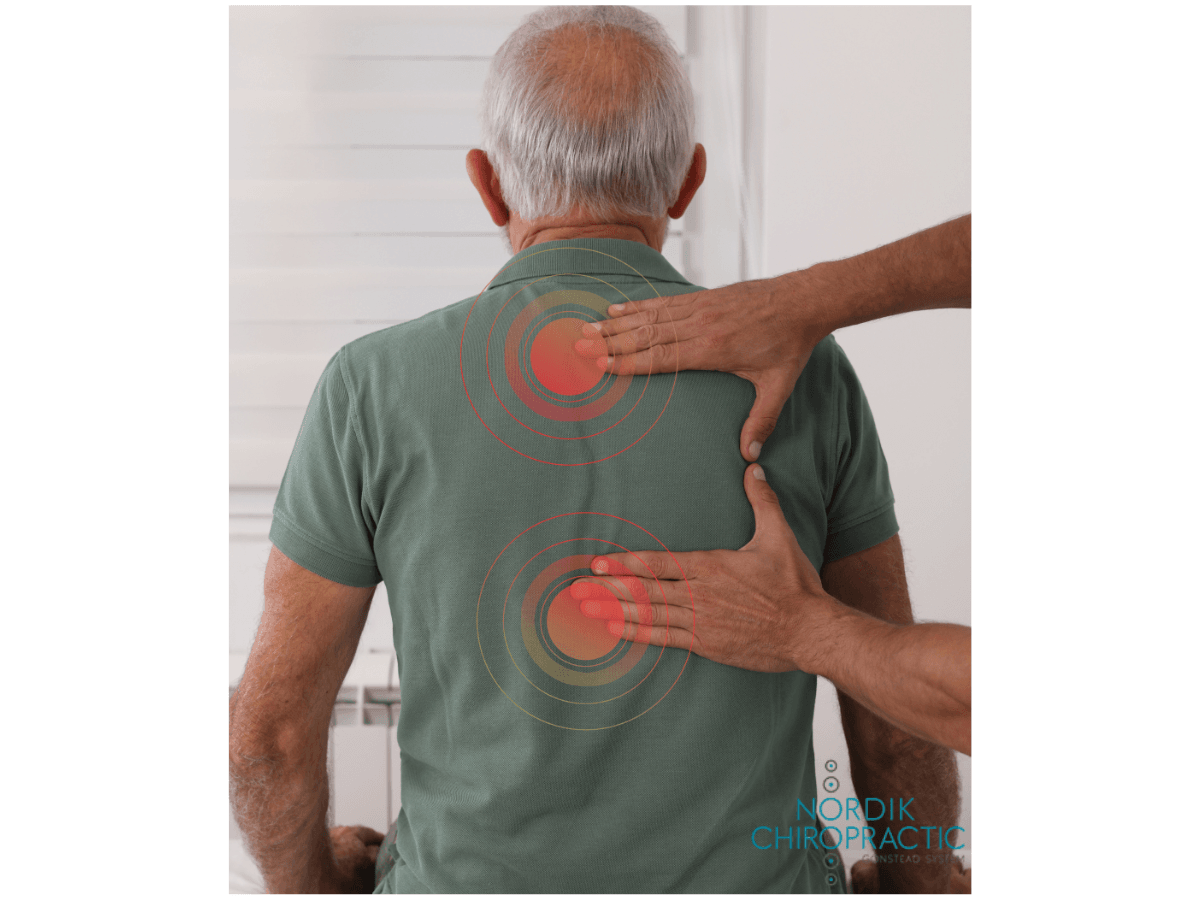 Hands pressing on a person’s upper and lower back, indicating a back massage or pain relief treatment.