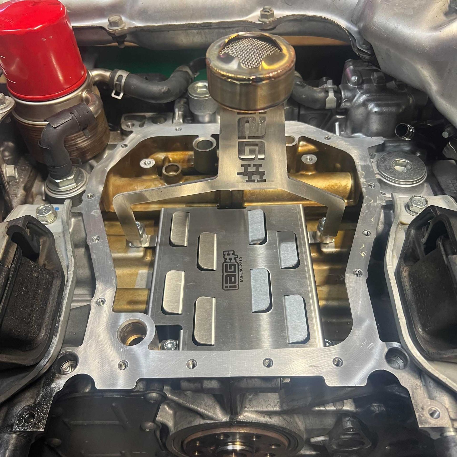 Open car engine with a metal baffle plate installed, gold and silver components.