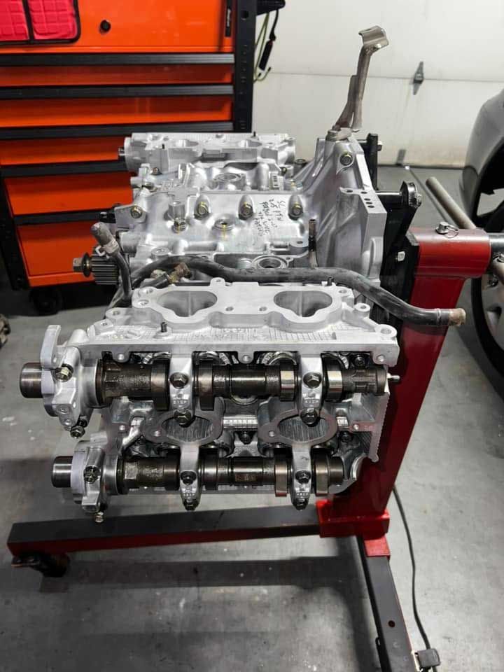 Engine mounted on a red stand; silver engine components visible.