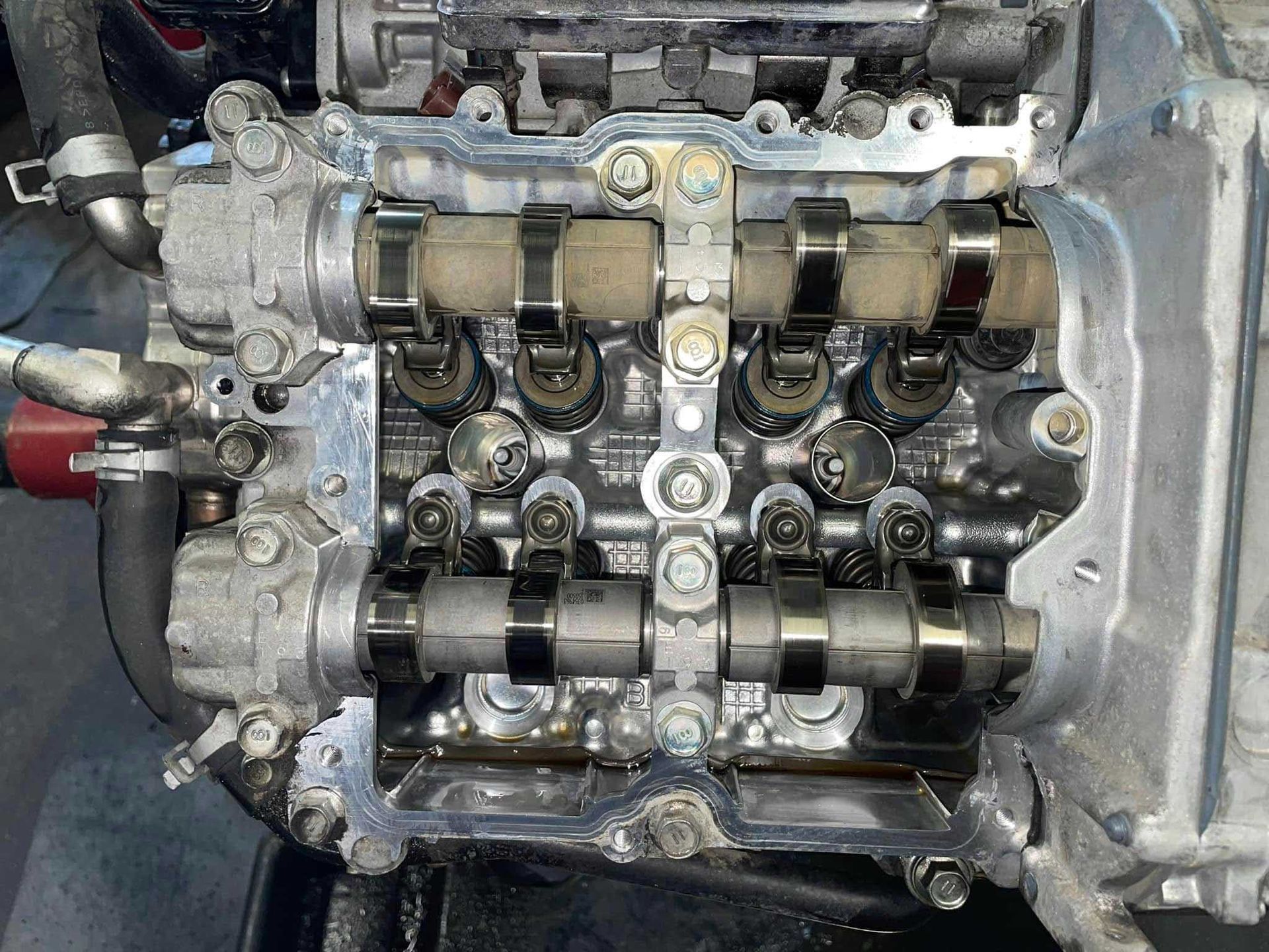 Overhead view of a car engine's cylinder head with exposed camshafts and valves.
