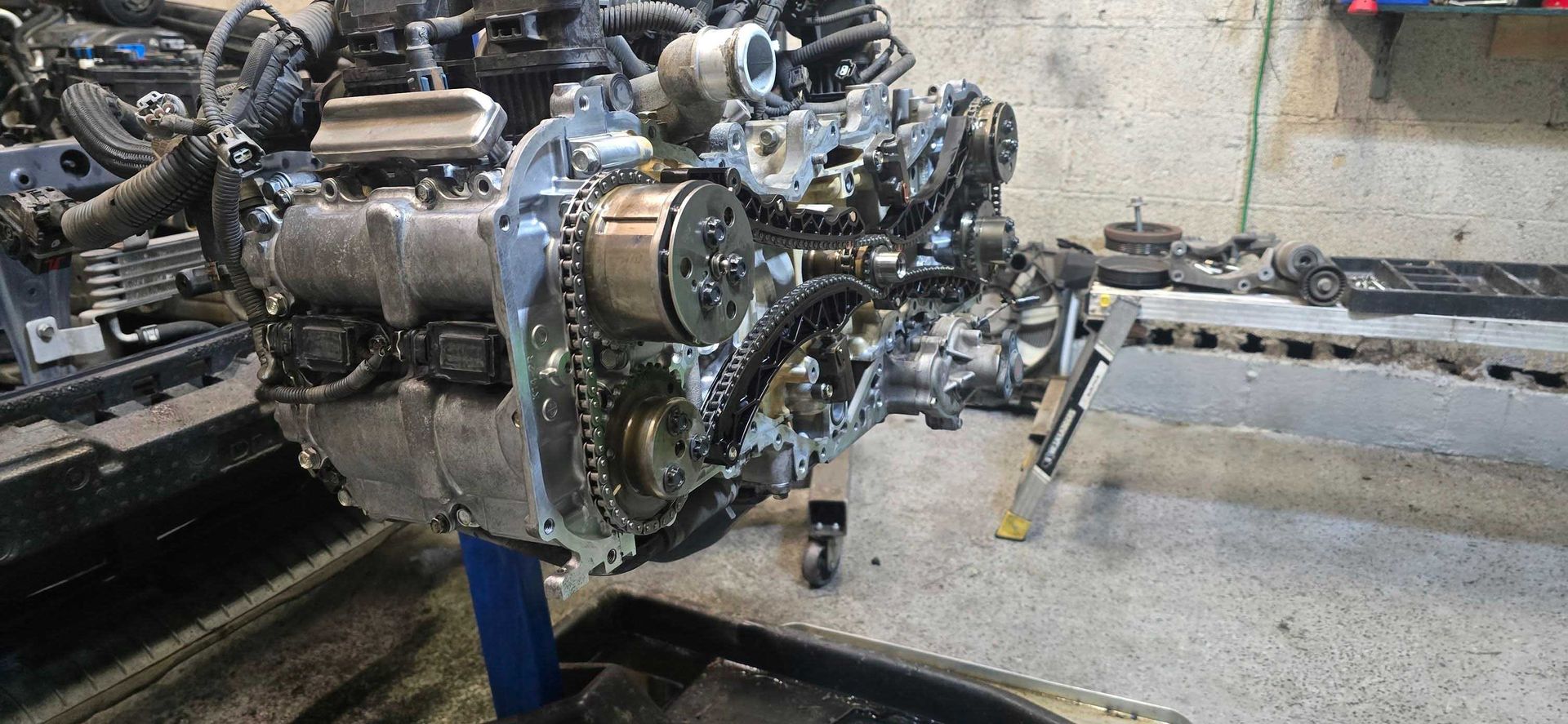 Partially disassembled car engine in a repair shop.