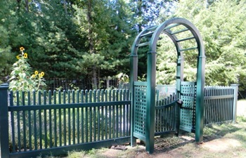 A green fence with a wooden archway in the middle
